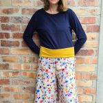 Linen flare pants with yellow, pink, blue and orange flowers and a yellow waist band